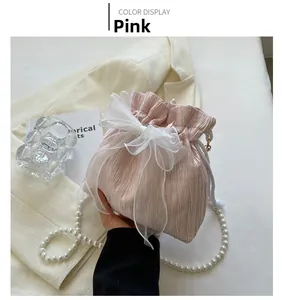 Detail of pink pleated bucket bag with large organza bow and pearl chain strap