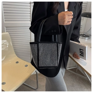 Detailed view of black rhinestone bucket bag with sparkling silver accents and double handles