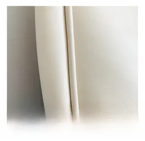 Close-up of beige leather tote bag showing fine stitching and litchi grain texture