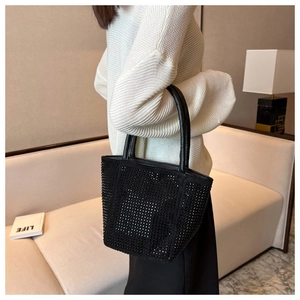 Detail of black rhinestone handbag showing shimmering texture on a stylish bucket bag