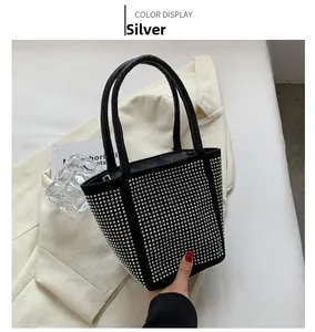 Macro detail of bucket bag featuring silver rivets on black matte texture fabric