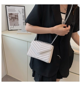 Detail of white V-quilted chain bag featuring premium leather texture and silver strap