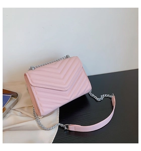 Detail of pink quilted handbag with chevron stitching and silver chain strap