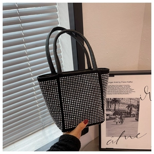 Detail of black rhinestone handbag featuring shimmering crystals and slim handles