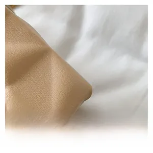Macro view of light brown quilted leather bag showing soft texture and stitching