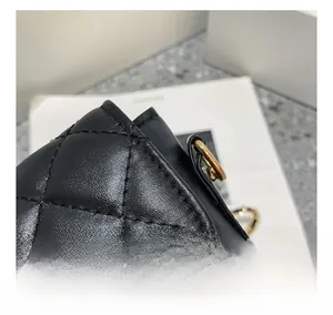 Macro detail of diamond quilted black leather stitching and golden metal hardware