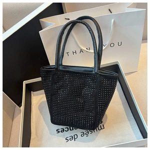 Detail of a black bucket bag featuring dense rhinestones and stylish round top handles