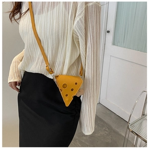 Close-up of yellow cheese shaped PU leather crossbody bag with triangular holes