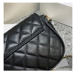 Close-up of quilted pattern and gold chain hardware on a black leather handbag