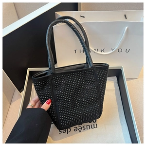 Detail of black rhinestone tote bag showing sparkling crystals and leather handles