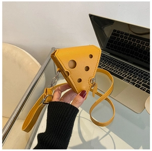 Detail shot of a yellow cheese-shaped mini crossbody bag with creative hollow holes