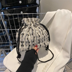 Knitted drawstring bucket bag with wave pattern weave and black top handle handheld