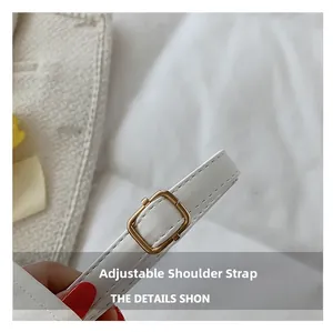 Detail of adjustable white leather shoulder strap with a square golden metal buckle