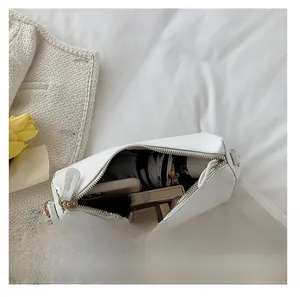 Interior view showing the large capacity of a white leather crossbody bag with daily items