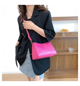 Detail of rose pink matte leather crossbody bag with elegant gold hardware and strap