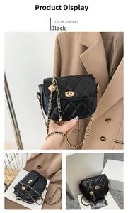 Detail of black quilted crossbody bag with golden chain strap and adjustable metal ball