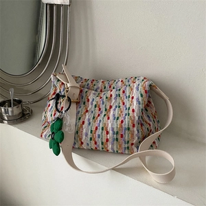 Multicolor woven tote bag with wide white leather strap and green floral charm