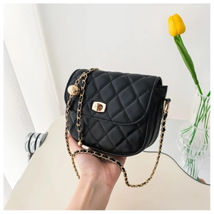 Close-up of quilted black leather chain bag with golden ball charm and metallic turn-lock