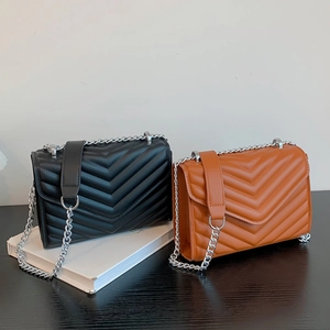 Quilted V-pattern crossbody bags in black and brown leather with silver chain straps