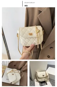 Detail of off-white quilted crossbody bag with gold chain strap and metal ball decor