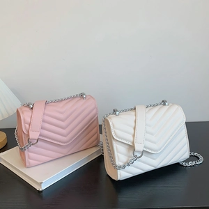 Quilted V-stitch chain crossbody bags in pink and beige displayed with a sleek flap design