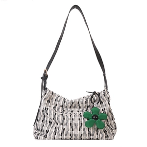 Fashion woven tote bag in black white and gray with green flower pendant on white background