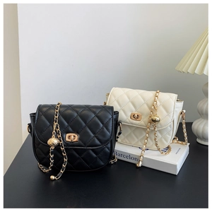 Detail of quilted leather saddle bags with gold chain and adjustable metal ball buckle
