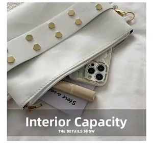 Detail showing internal capacity of the white leather rivet bag with phone and lipstick