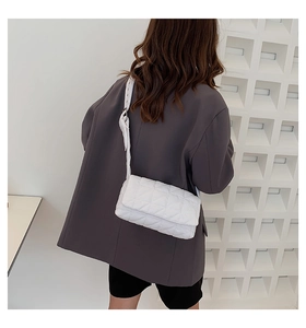 White quilted shoulder bag with large lattice pattern shown on model with wide strap