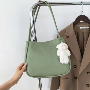 Minimalist green soft leather tote bag with shoulder straps and cute bear charm