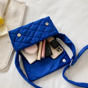 Intérieur du sac matelassé bleu en nylon montrant le rangement pour mobile et maquillage