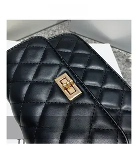 Close-up of golden rectangular twist lock on black quilted leather crossbody bag