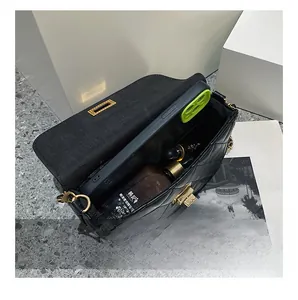 Interior view of black quilted chain bag with gold clasp showing spacious storage capacity