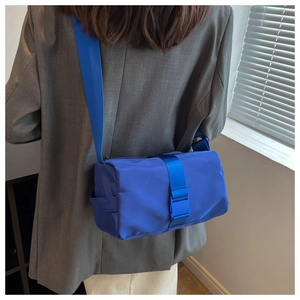 Detail of Klein blue nylon cylinder crossbody bag with plastic buckle and wide strap