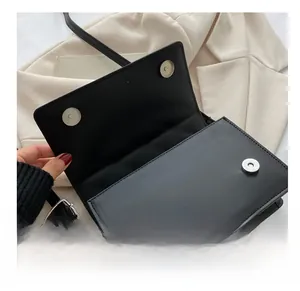 Detail of black quilted crossbody bag showing secure double magnetic snap closures