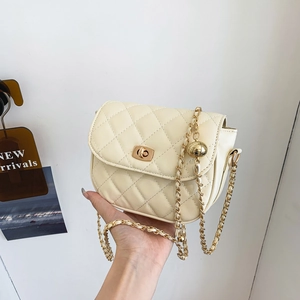 Cream quilted saddle bag with gold ball chain strap and metallic twist lock closure