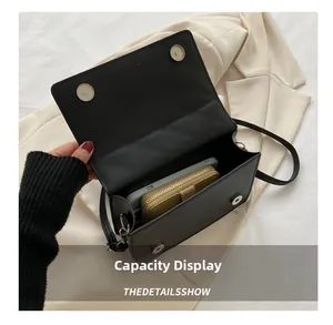 Internal view of black quilted bag showing capacity for phone and wallet with silver buttons