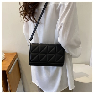Close-up of a stylish black quilted crossbody bag with geometric stitching for women