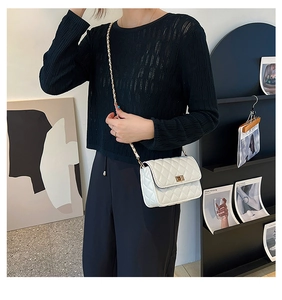White quilted chain shoulder bag shown on model for size perspective and style
