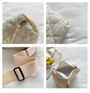 Detail view of cream white quilted crossbody bag showing zipper and adjustable strap