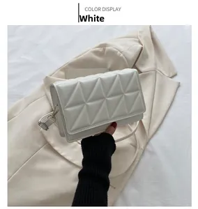Close-up of white PU leather crossbody bag with triangular quilted stitching details