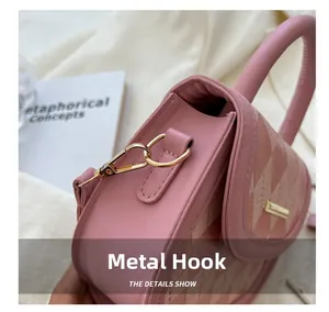 Detail shot of the golden hardware hook on a pink quilted saddle bag with texture
