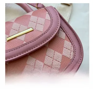 Detailed close-up of pink quilted faux leather handbag with neat stitching and gold buckle