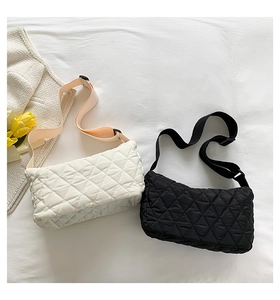 Close-up of quilted puff shoulder bags in black and white with adjustable straps