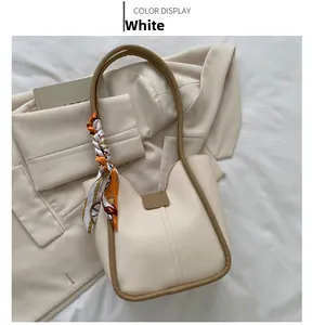 Détails du sac fourre-tout blanc minimaliste avec un foulard orange décoratif