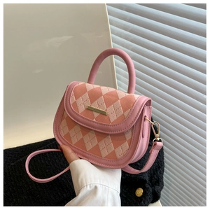 Detailed macro view of a pink quilted mini handbag with gold metal clasp and handle