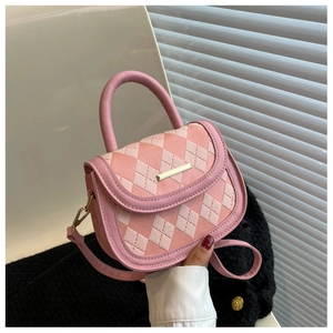 Detail of pink quilted pattern leather surface and gold metal clasp on the saddle bag