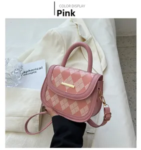 Detail view of pink quilted crossbody bag showing refined faux leather texture and metallic bar