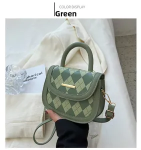 Detail of green quilted crossbody bag with golden hardware held by hand