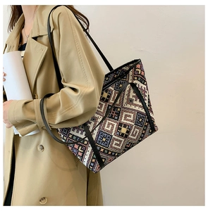 Close-up of geometric woven tote bag detailing colorful ethnic patterns and leather straps